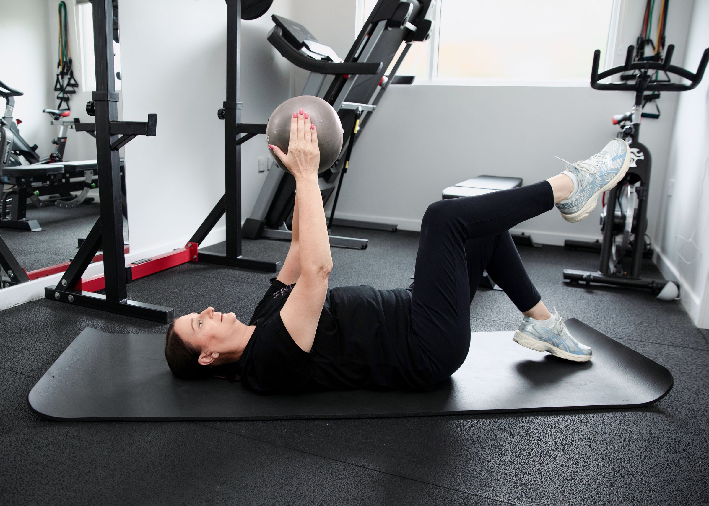 Suzy doing a core exercise in her fully equipped private women's gym in Dore, Sheffield
